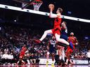 Gradey Dick of the Toronto Raptors drives to the net against Caleb Martin of the Dallas Mavericks during Sunday's game.