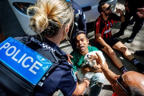 A member of the Iranian community in Australia reacts as a police officer removes him from the path of a departing bus transporting members of the Iranian Women's Asia Cup football team to the airport, outside the Royal Pines Resort on the Gold Coast on March 10.
