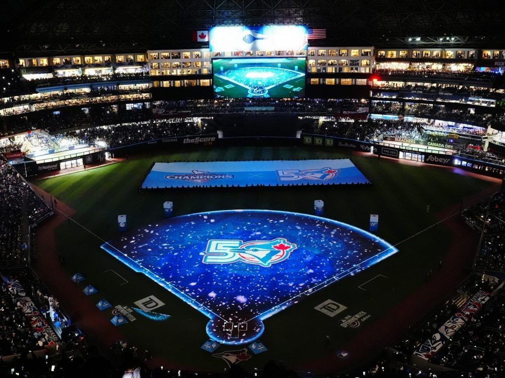 Fans and players watch a pregame ceremony prior to  MLB baseball action between the Toronto Blue Jays and the Athletics in Toronto on March 27, 2026. 