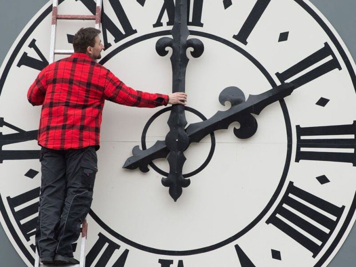 A man adjusts a clock