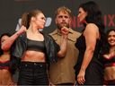 Ronda Rousey (L) and Gina Carano (R) face off in front of Jake Paul (C) during the Most Valuable Promotions (MVP) and Netflix 5X5 Professional MMA bound pre-fight press conference outside the Intuit Dome in Inglewood, California on March 10, 2026.