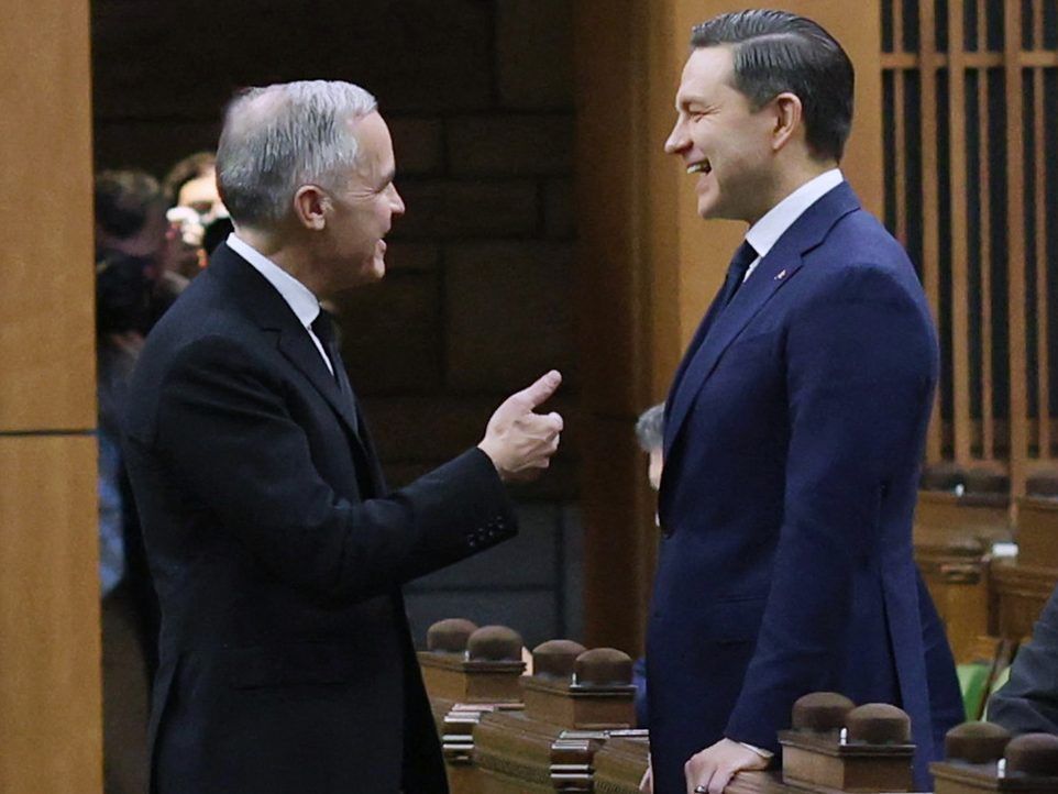 Canada's Prime Minister Mark Carney (left) speaks with Conservative Party Leader Pierre Poilievre in the House of Commons on Parliament Hill on Feb. 11, 2026 in Ottawa.