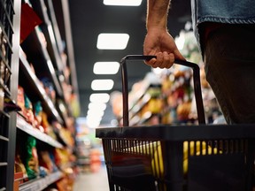Close up of man with shopping basket buying groceries at the store.