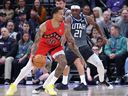 Toronto Raptors guard Markelle Fultz (20) dribbles against Utah Jazz guard Bez Mbeng (21) during the first half of an NBA basketball game, Monday, March 23, 2026, in Salt Lake City.