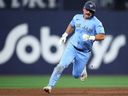 Davis Schneider of the Toronto Blue Jays runs to third base on a single by Andres Gimenez in the eighth inning of a game against the Los Angeles Dodgers at Rogers Centre on April 8, 2026 in Toronto