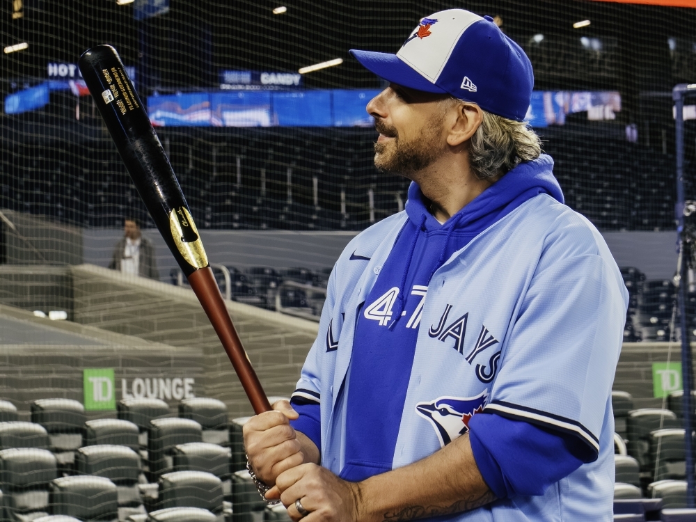 Rogers Game Day Owner Paul Bychko examines a game-used bat.