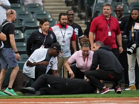 People tend to a man who collapsed while singing "Lift Every Voice and Sing" before a baseball game between the Tampa Bay Rays and Chicago White Sox.