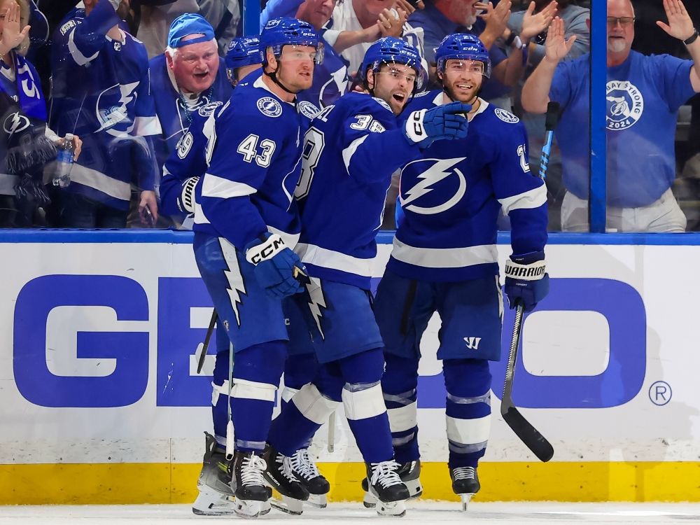 Brandon Hagel (centre) of the Tampa Bay Lightning celebrates his goal against the Montréal Canadiens with Darren Raddysh #43 and Brayden Point.