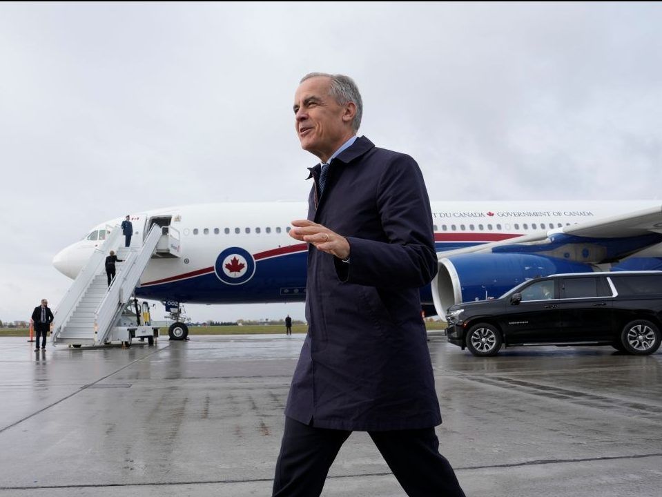 Prime Minister Mark Carney speaks with members of the media before he boards a government plane in Ottawa on Friday Oct. 242025.