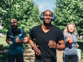 Group of friends jogging together in the park on a sunny day