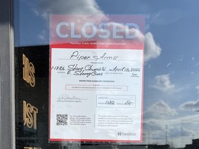 Red closed notice from Hamilton Public Health on door of Piper Arms in Stoney Creek.