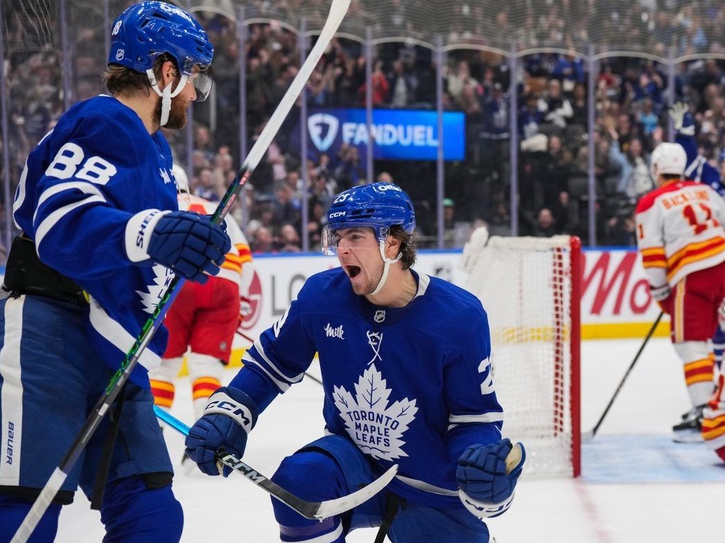 Matthew Knies #23 of the Toronto Maple Leafs celebrates his second period goal against the Calgary Flames with William Nylander #88 at Scotiabank Arena on October 28, 2025 in Toronto, Ontario, Canada.