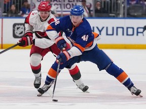 New York Islanders' Matthew Schaefer (48) drives past Carolina Hurricanes' Eric Robinson (50) during the second period of an NHL hockey game Tuesday, April 14, 2026, in Elmont, N.Y.