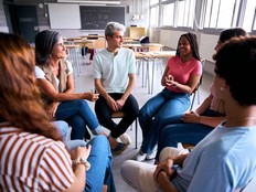 Students and teacher having group discussion in circle