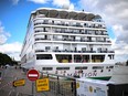 Passengers stand aboard the Bahamas-registered cruise ship Ambition after they were confined following the outbreak of a gastrointestinal illness onboard, at the Bordeaux port in Bordeaux, southwestern France on May 13, 2026.
