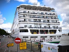 Passengers stand aboard the Bahamas-registered cruise ship Ambition after they were confined following the outbreak of a gastrointestinal illness onboard, at the Bordeaux port in Bordeaux, southwestern France on May 13, 2026.