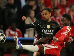 Alphonso Davies (R) stretching for a ball against Bradley Barcola of Paris Saint-Germain in a Champions League semi-final second-leg.