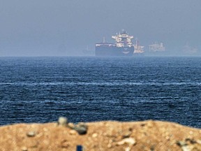 Cargo ships are seen at sea near the Strait of Hormuz, as viewed from a rocky shoreline near Khor Fakkan, United Arab Emirates, Friday, May 1, 2026.