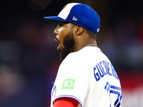 Vladimir Guerrero Jr. of the Toronto Blue Jays reacts to a play by pitcher Tyler Rogers during a game against the Philadelphia Phillies.