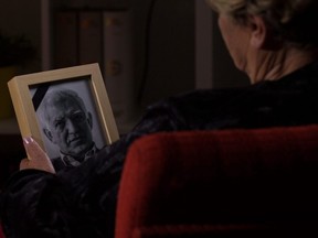 A widow holds a photo of her late husband.