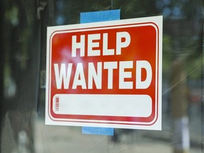 A help wanted sign in front of a storefront