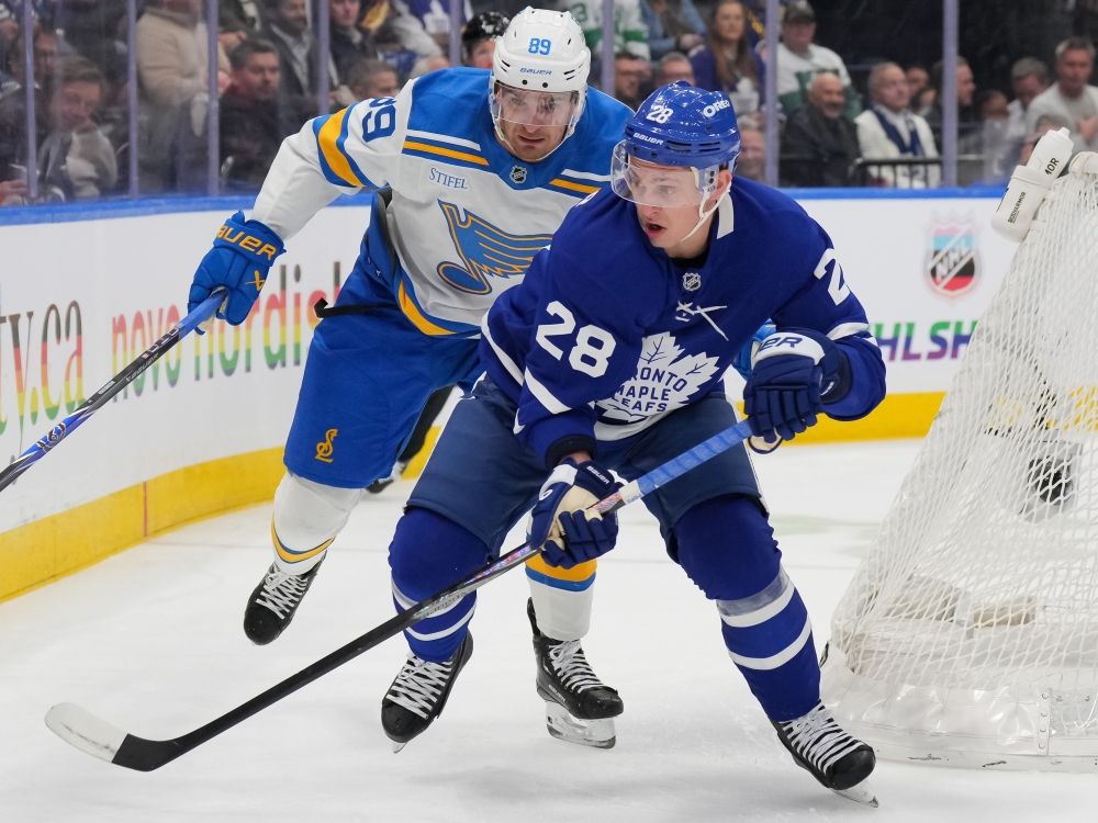 Troy Stecher of the Toronto Maple Leafs chases the puck against Pavel Buchnevich of the St. Louis Blues.