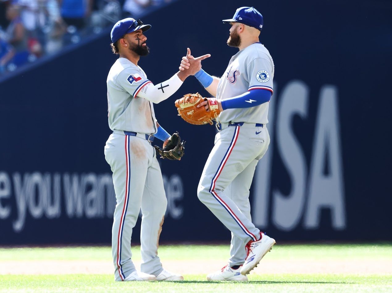 Ezequiel Duran and Jake Burger of the Texas Rangers celebrate at the end of their MLB game.