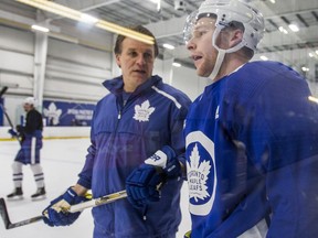 Former Maple Leafs assistant coach Jim Hiller (left), seen here chatting with Connor Brown in December 2018, has been hired by the team as their next head coach.