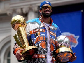 Karl-Anthony Towns of the New York Knicks celebrates with the Larry O'Brien Championship Trophy and the Bob Cousy Trophy during the ticker tape parade and victory rally in New York City celebrating their NBA championship on Thursday, June 18, 2026.