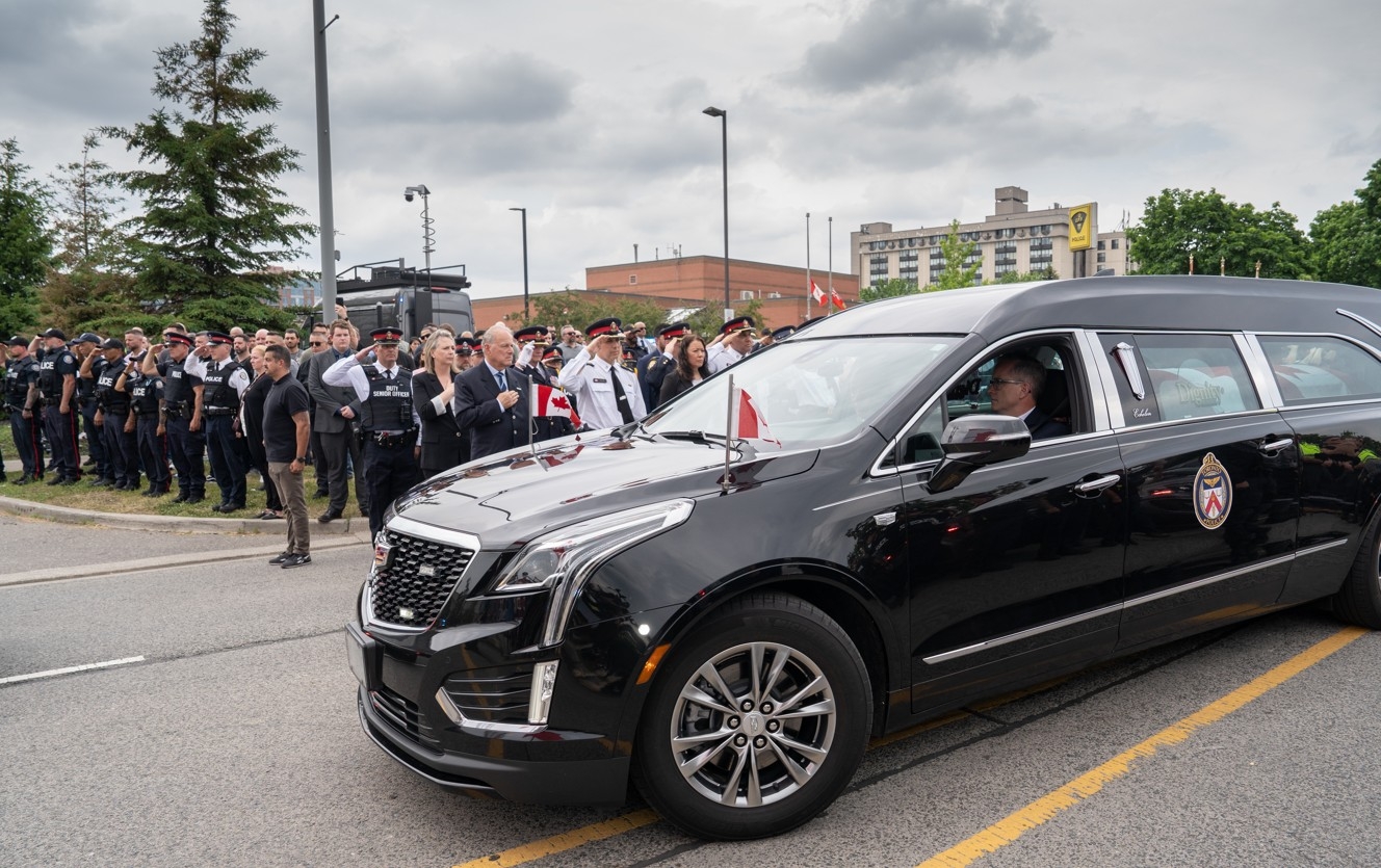 Police, emergency personnel, politicians and civilians show their respect as the motorcade from Sunnybrook Hospital delivered the body of Toronto Police Const. Marc Pinizzotto to the Chief Coroner’s Office in Toronto on Thursday, June 11, 2026.