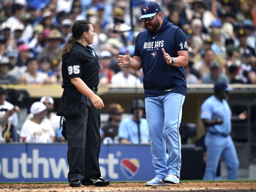 Umpire Jen Pawol talks with manager John Schneider of the Toronto Blue Jays during a game against the San Diego Padres.