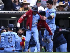 Ernie Clement of the Toronto Blue Jays has the home run jacket placed on him by Brandon Valenzuela after hitting a two-run home run against the San Diego Padres.