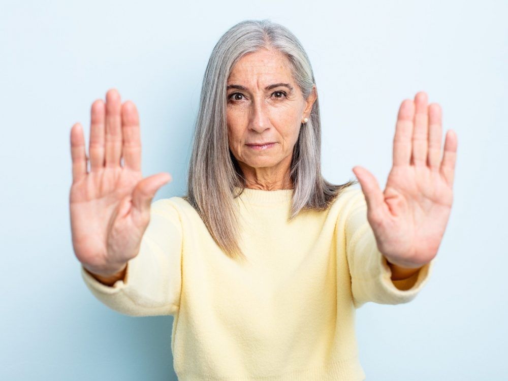 An older woman looks serious and unhappy.