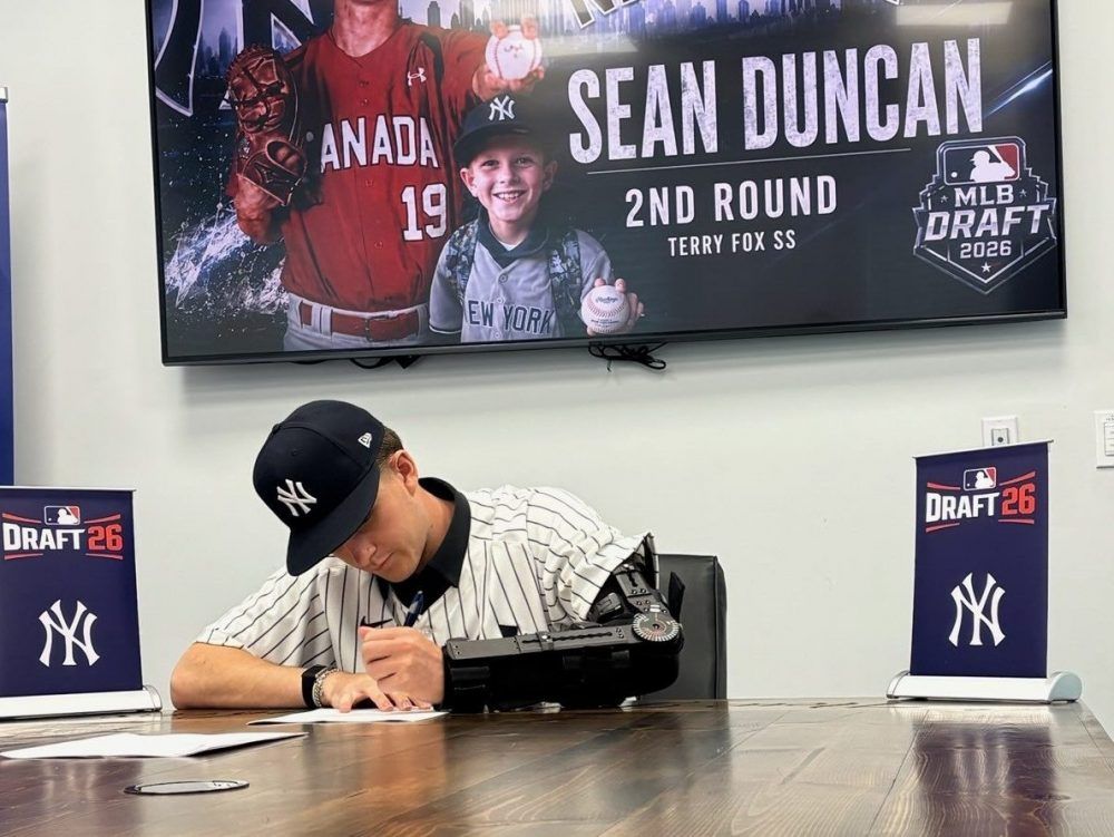 Sean Duncan, his left arm still in a post-surgical brace, signs with the New York Yankees.