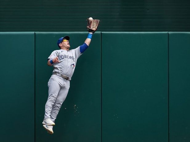 Daulton Varsho #5 of the Toronto Blue Jays makes a leaping catch at the wall on a hit by Brady House #12 of the Washington Nationals during the first inning at Nationals Park on July 29, 2026 in Washington, DC.