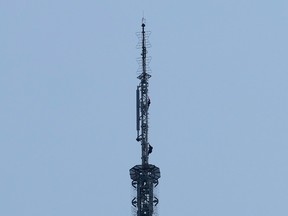 Two people climb on the spire of the Empire State Building in New York on July 1, 2026.