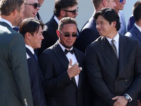 (LR) Yoshinobu Yamamoto #18, Miguel Rojas #72 ו-Shohei Ohtani #17 מהלוס אנג'לס דודג'רס מגיבים כאשר נשיא ארה