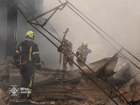This handout photo taken and released by Ukrainian State Emergency Service shows firefighters extinguishing a fire at a warehouse that was damaged following Russian missile strikes on the Ukrainian capital Kyiv, Saturday, July 11, 2026.