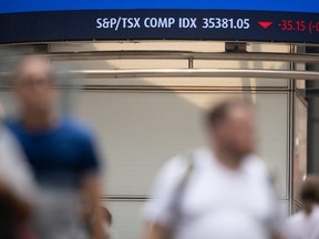 The stock ticker at the BMO building on the corner of Bay and King Streets with pedestrians walking by in Toronto, Ontario on Thursday, July 16.