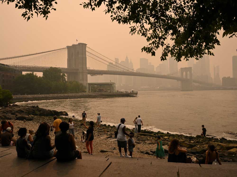 People look at the Brooklyn Bridge as wildfire smoke from Canada causes hazy conditions on July 16, 2026 in New York. 