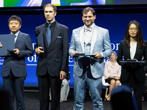 Chinese mathematician Yu Deng, U.S. mathematician John Pardon, Canadian mathematician Jacob Tsimerman and Chinese mathematician Hong Wang pose for photos onstage after receiving their Fields Medals during the International Congress of Mathematicians in Philadelphia on July 23, 2026.