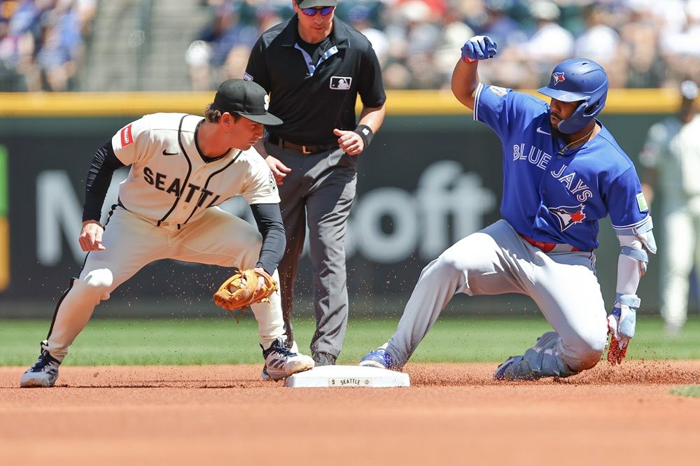 Cole Young of the Seattle Mariners look to tag Vladimir Guerrero Jr. of the Toronto Blue Jays as he slides into second base safely for a double during the first inning at T-Mobile Park on Sunday, July 5, 2026 in Seattle. 