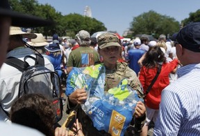 A National Guard member hands out water to visitors waiting to enter the Great American State Fair in Washington, D.C., Saturday, July 4, 2026.