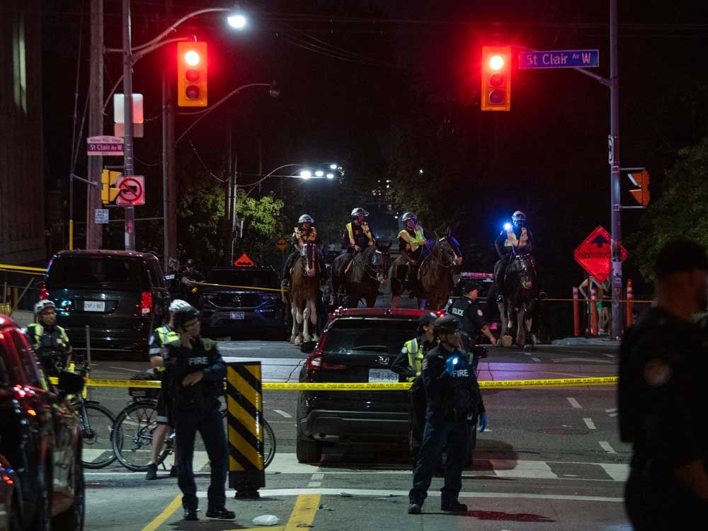 Police officers and other law enforcement personnel block off access to the intersection of St. Clair W. and Arlington Ave., near the site of a shooting that occurred at the Salsa on St. Clair festival in Toronto on July 11, 2026.