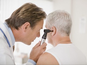 A doctor examines a patient's ear.