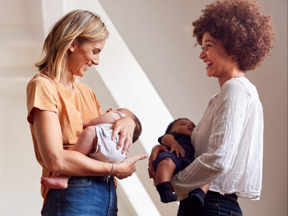 Two mothers hold newborn babies.