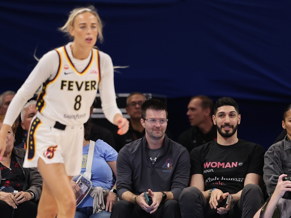 Former NBA player Enes Kanter Freedom watches Sophie Cunningham of the Indiana Fever courtside during a game against the Chicago Sky.