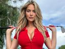 Golf influencer Paige Spiranac poses for a photo holding a golf club.