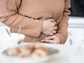Woman has stomach ache while eating food,stomach disease,gastric ulcer,acute gastritis,pain in abdomen,abdominal discomfort,irritable bowel syndrome,digestive problems,intestinal infection,health care