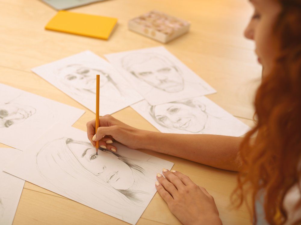 Red-haired creative person drawing caricatures